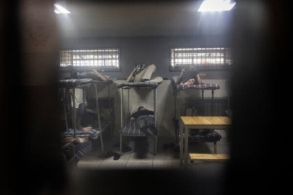 Russian prisoners of war lie on bunk beds inside a Ukrainian prison cell.
